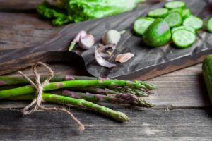 Fresh green asparagus spears arranged on a wooden cutting board, ready for cooking. Title: Fresh asparagus ready for spring recipes