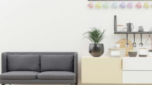 A bright and inviting living room featuring modern furniture, decorative cushions, indoor plants, and warm layered lighting.